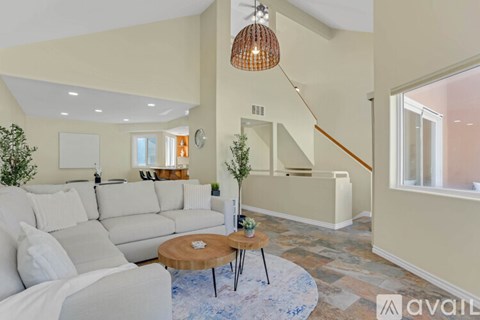 A living room with a white couch and a wooden coffee table.