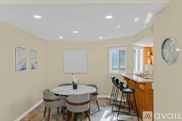 A kitchen with a dining table and chairs.