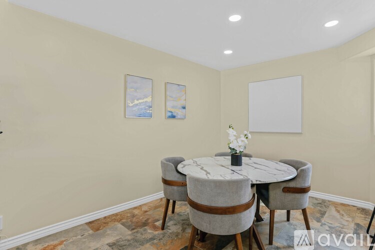 A dining room with a round table and chairs.