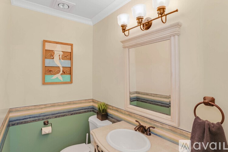 A bathroom with a green wall and a white sink.
