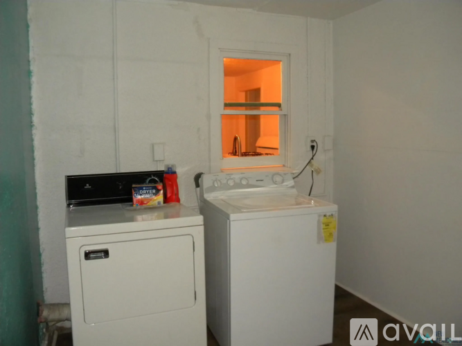 A small white washing machine and dryer in a small room.