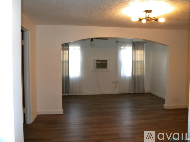A room with wooden floors and a flat screen TV mounted on the wall.