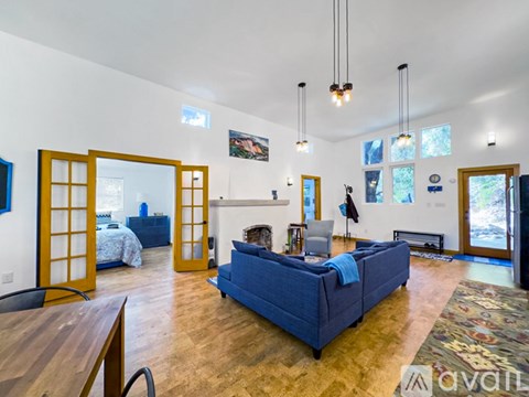 A living room with a blue couch and wooden floors.