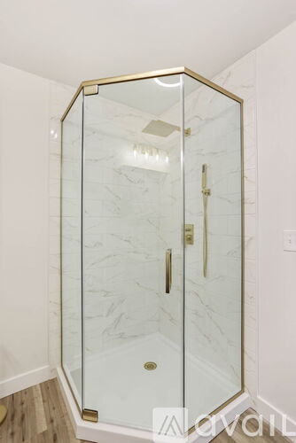 A white marble bathroom with a glass shower stall.