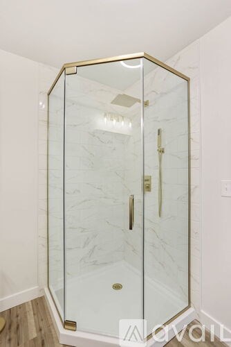 A white marble bathroom with a glass shower stall.