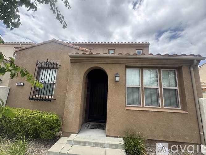 A house with a brown facade and a black door is for sale.