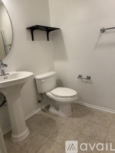 A white toilet sits next to a sink in a small bathroom.