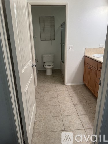 A bathroom with a toilet, sink, and cabinet.