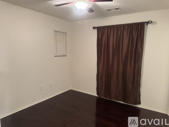 A room with a brown curtain and a ceiling fan.