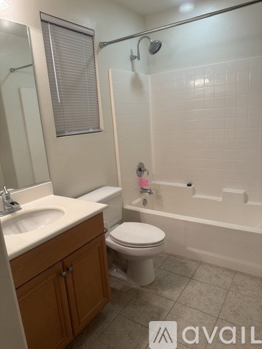 A bathroom with a toilet, sink, and bathtub.