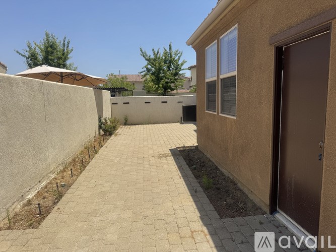 A patio area with a brown door and tan walls.