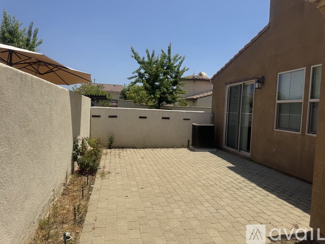 A patio area with a tiled floor and a wall on one side.