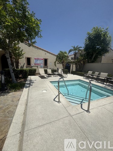 A pool with a ladder and a building in the background.