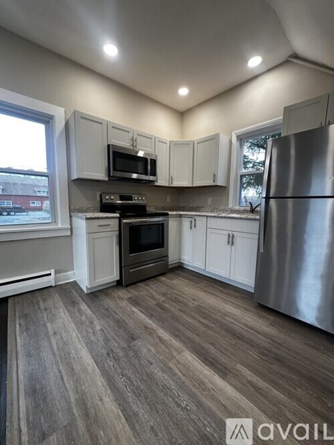 A kitchen with a refrigerator, stove, and microwave.