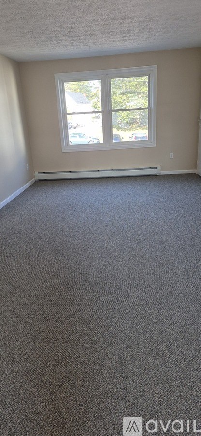A room with a carpeted floor and a window.