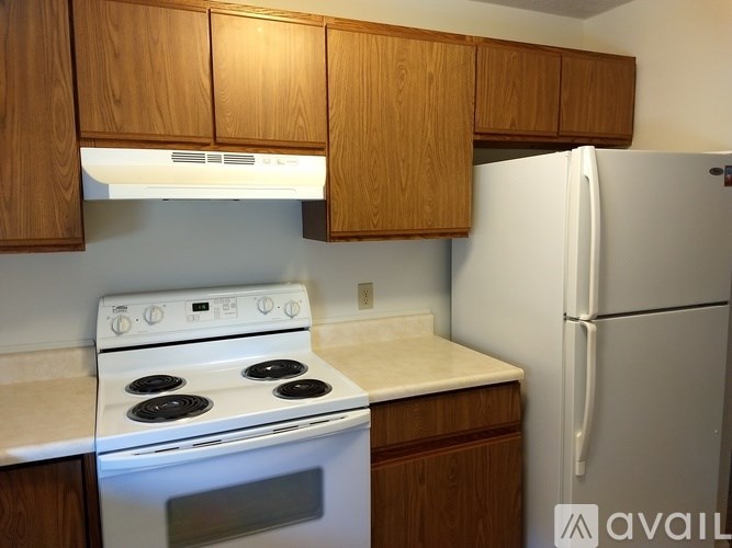 A kitchen with a white stove and a white refrigerator.
