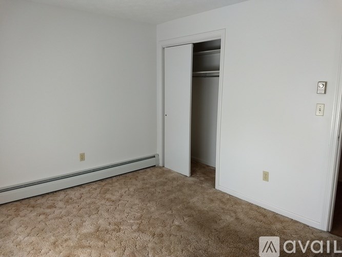 A room with a carpeted floor and a doorway leading to another room.