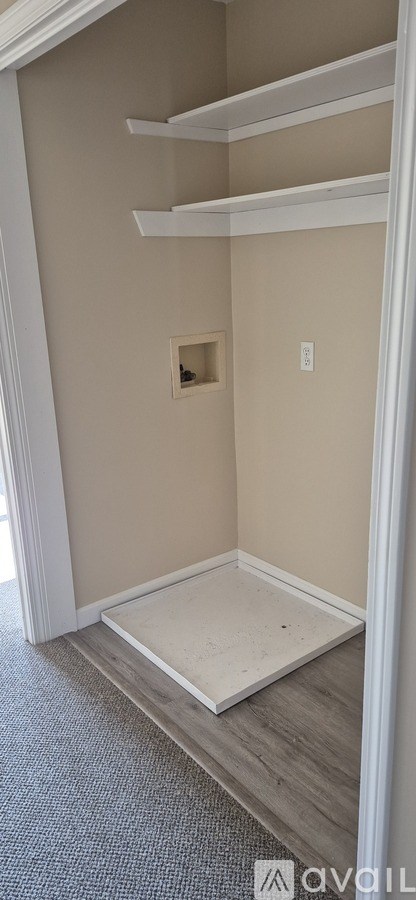 A room with a small window and a doorway leading to another room.