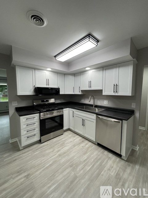 A modern kitchen with white cabinets and stainless steel appliances.
