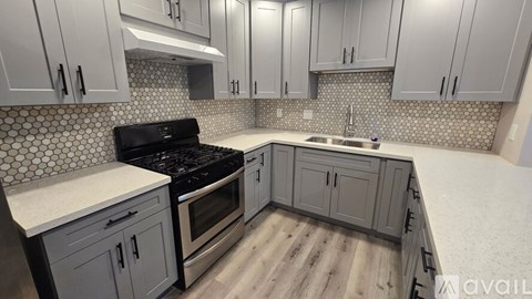 A kitchen with a black stove top oven and white countertops.