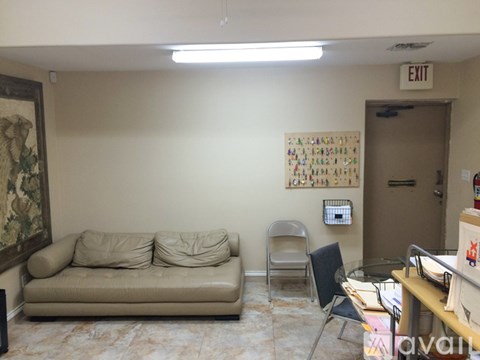 A living room with a couch, chair, and a painting on the wall.