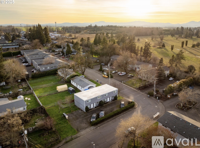 A bird's eye view of a residential area with houses and a parking lot.