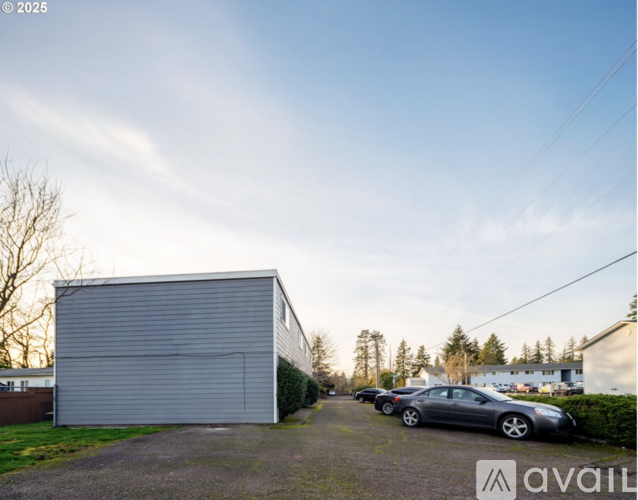 A grey garage with a car parked in front of it.