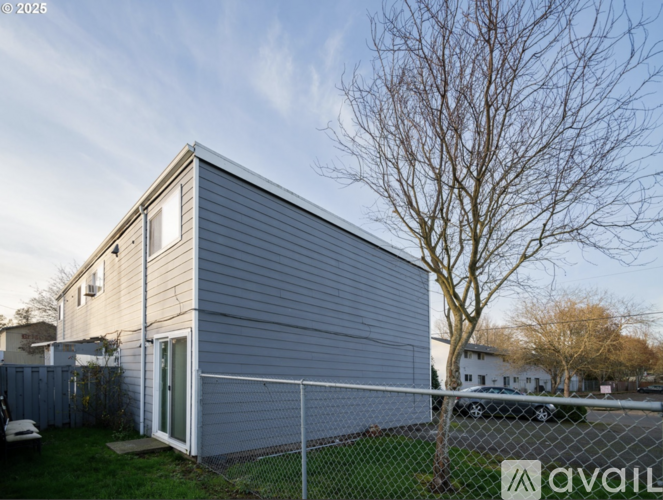 A modern house with a grey exterior and a tree in front.