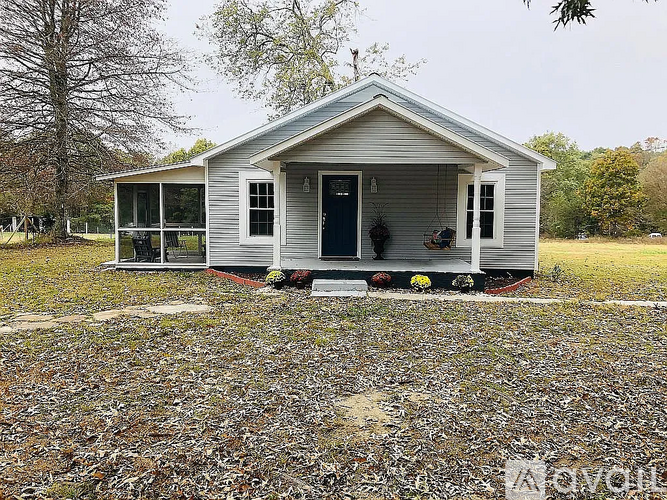 A small house with a porch and a covered patio.