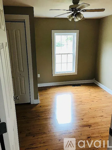 A room with a ceiling fan and a window.