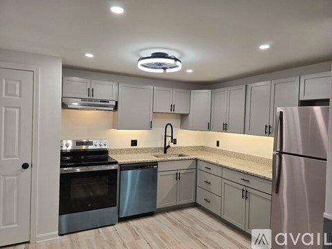A kitchen with white cabinets and a stainless steel refrigerator.