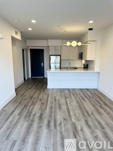 A kitchen with a white counter and a black door.