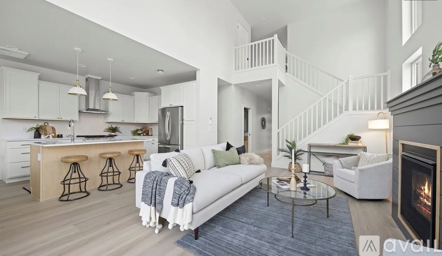 A modern living room with a fireplace and a staircase.
