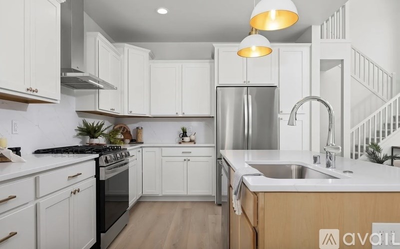 A modern kitchen with white cabinets and stainless steel appliances.