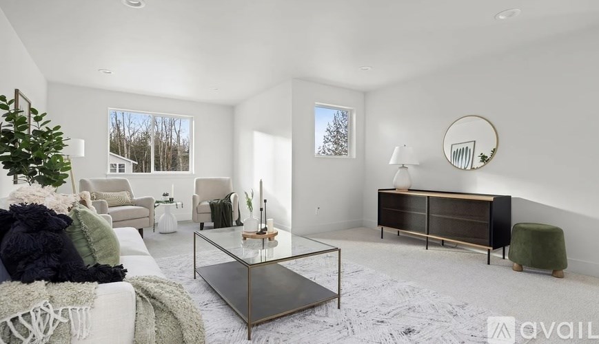 A modern living room with a glass coffee table and a green armchair.