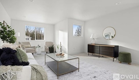 A modern living room with a glass coffee table and a green armchair.
