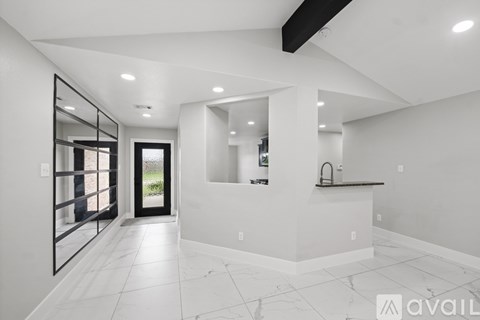A modern kitchen with white cabinets and a black countertop.