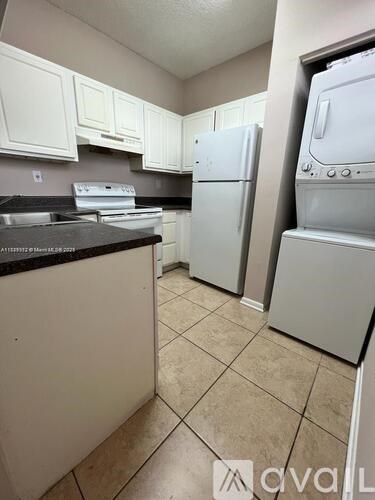 A kitchen with white appliances and cabinets.