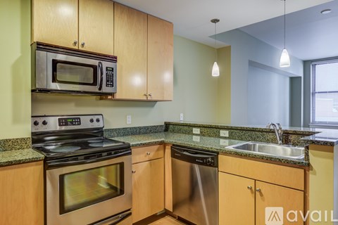 A kitchen with wooden cabinets and a stainless steel dishwasher.