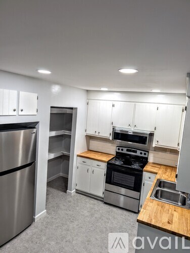 A kitchen with a stainless steel refrigerator and a wooden countertop.