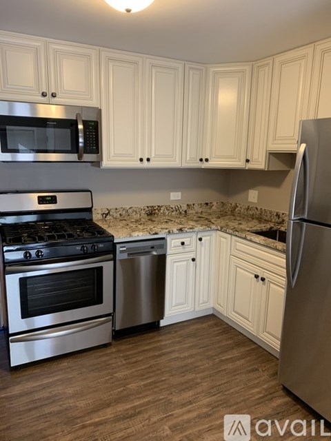 A kitchen with a stove, oven, microwave, and refrigerator.