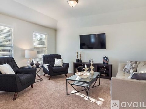 A living room with a black chair and a glass coffee table.