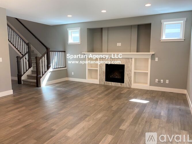 A spartan agency office with wood flooring and a staircase.