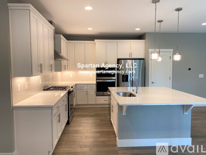 A modern kitchen with white cabinets and a large island.