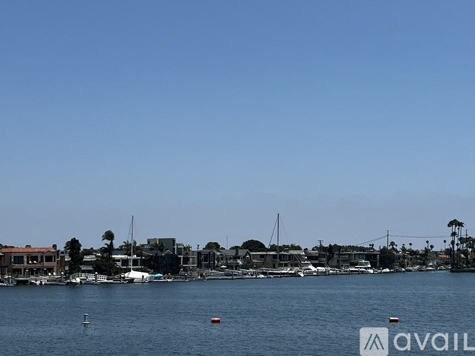 A body of water with a dock and houses in the background.