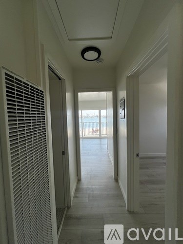 A long hallway with a window and a sign that says "avail".