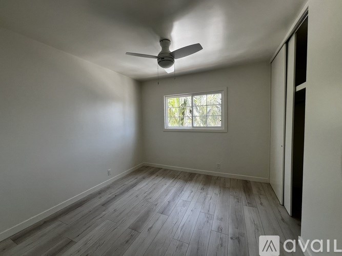 A room with a ceiling fan and a window.