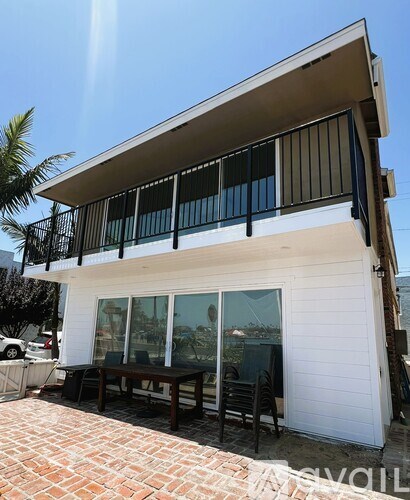 A white house with a balcony and a table outside.