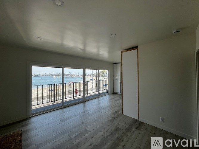 A room with a view of the beach through the windows.