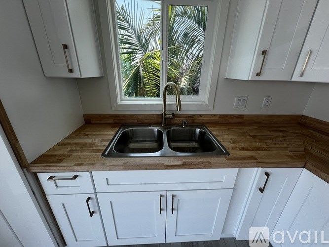 A kitchen with a wooden countertop and white cabinets.